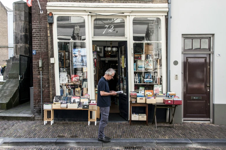 a man standing next to an open book store