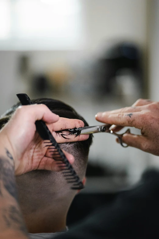 a man that has scissors in his hand with a hair brush