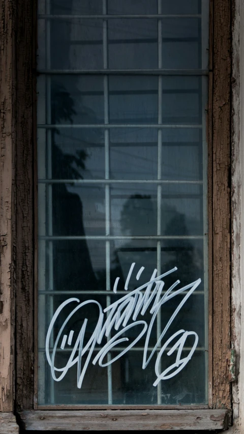 a window that has graffiti on the glass in front of it