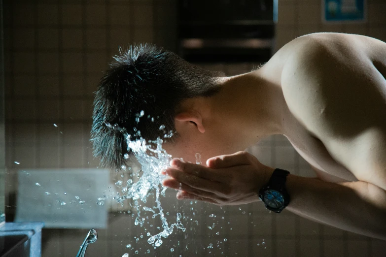 a young man looks down and bends his head