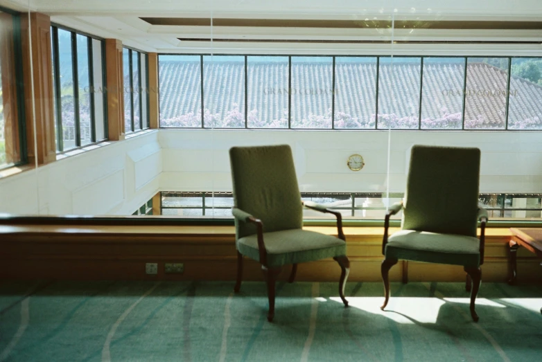 a view of the inside of a building of two chairs near a large window