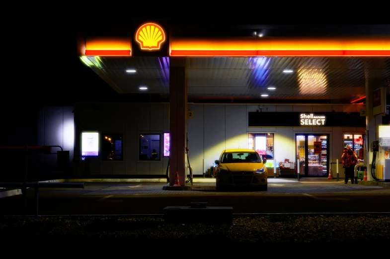 a yellow car is parked outside a gas station