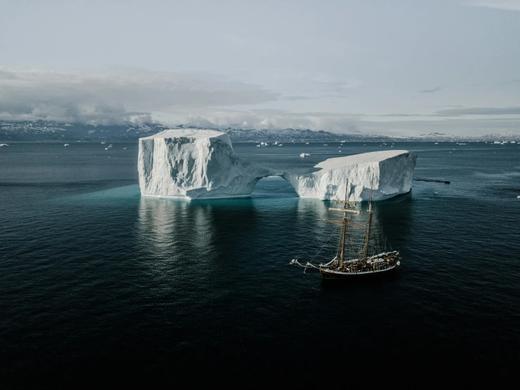 there is a boat that is in the water near icebergs