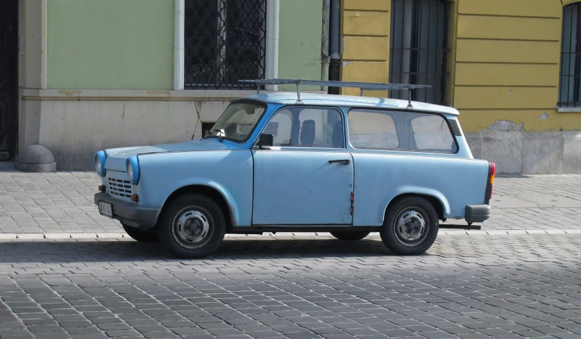 a blue car is parked in front of a yellow building