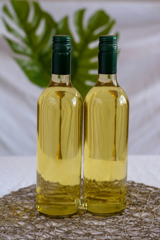 two bottles of green liquid sitting on top of a table