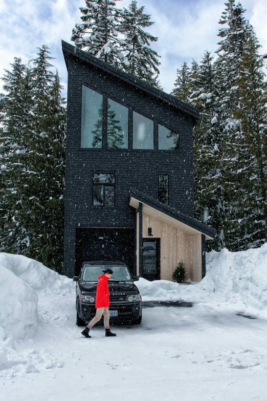 the car is parked outside of a cabin and covered with snow