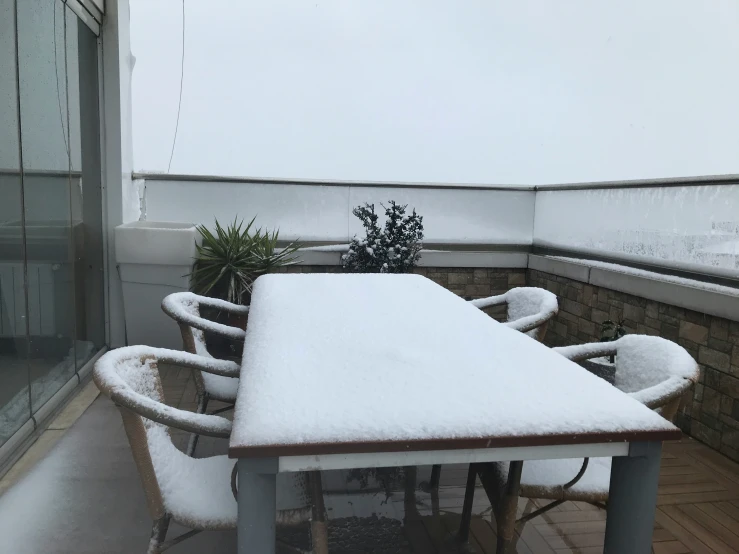 this is a table and chairs covered in snow