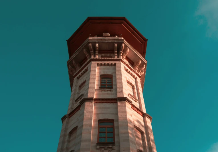 a tall white building with red bricks is against the blue sky