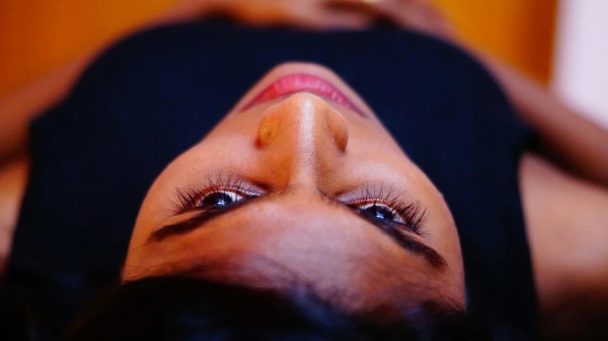 a woman with brown eyes laying down