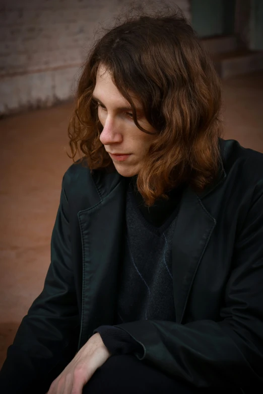 a man with long red hair looks up