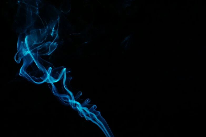 smoke trails against a black background with light