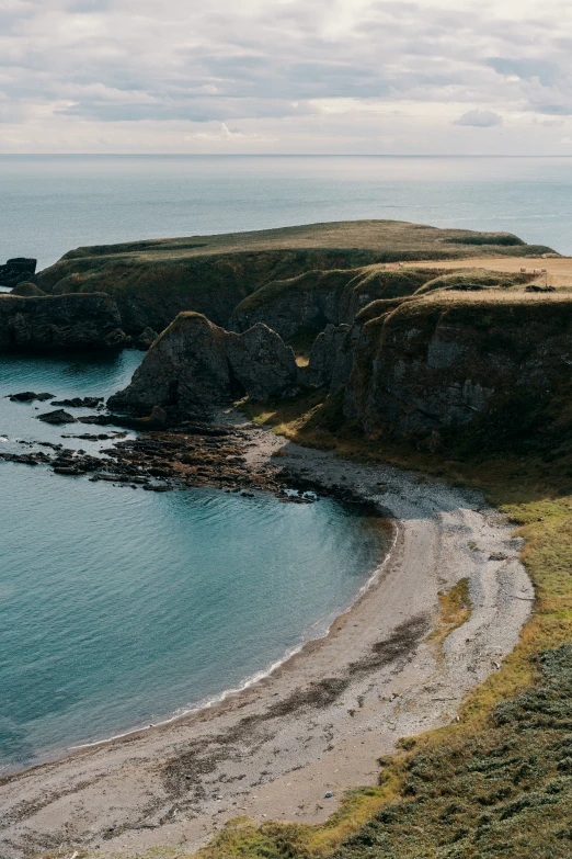 an aerial po shows the beach, cliff, and sea