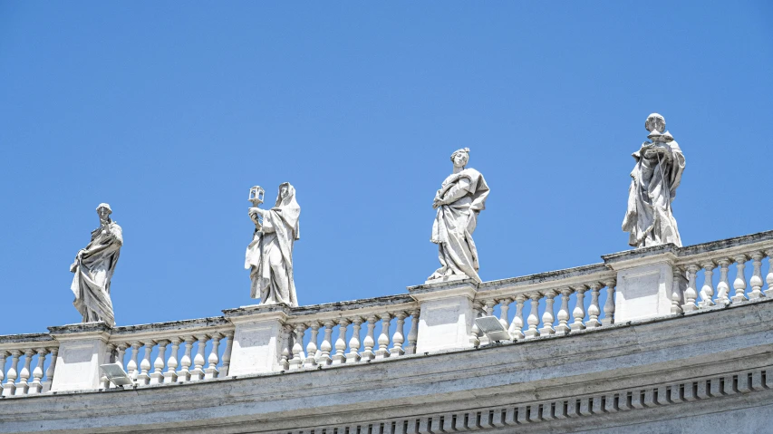 four statues on top of an old building