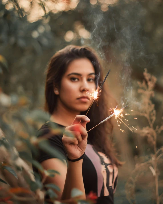 the woman is holding a sparkler on her finger