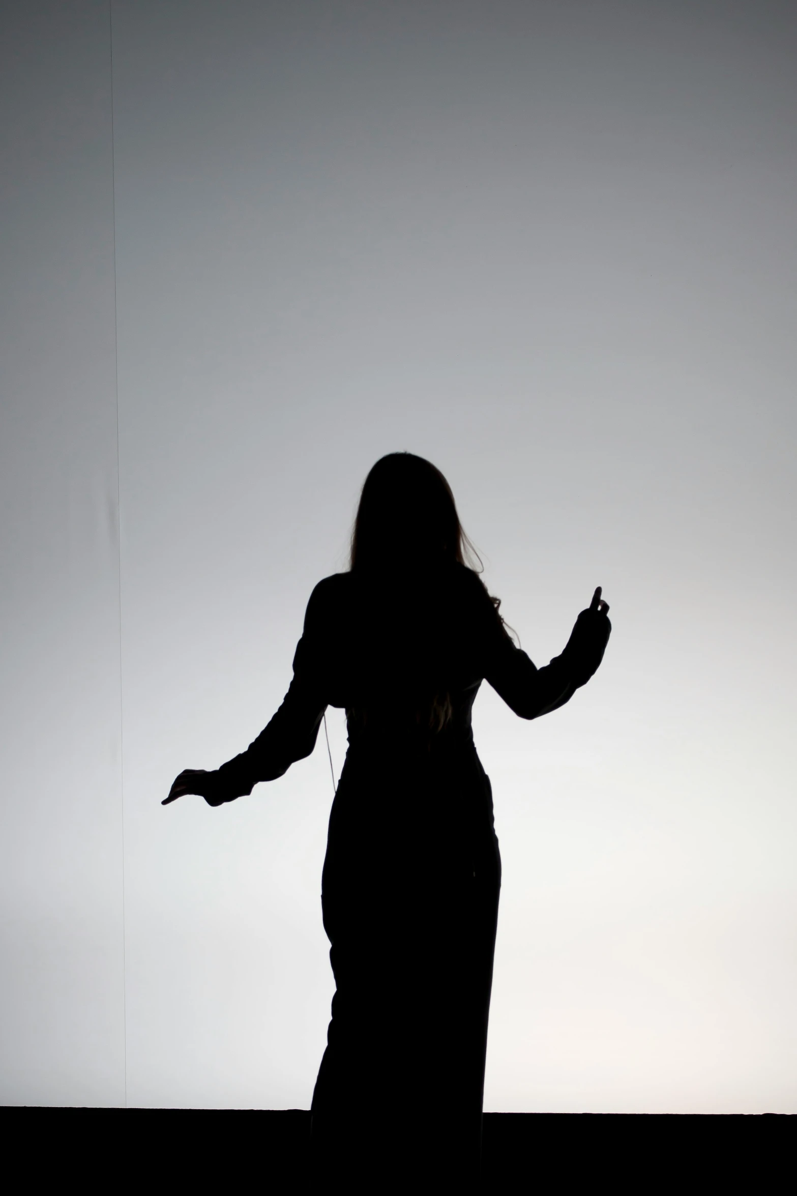 a person in the silhouette holding their hands out to an object