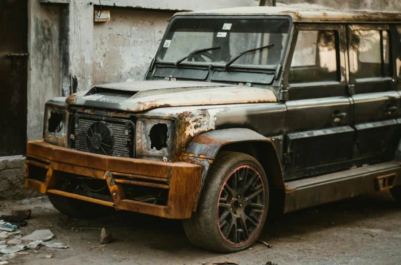 a dirty car parked in front of a building