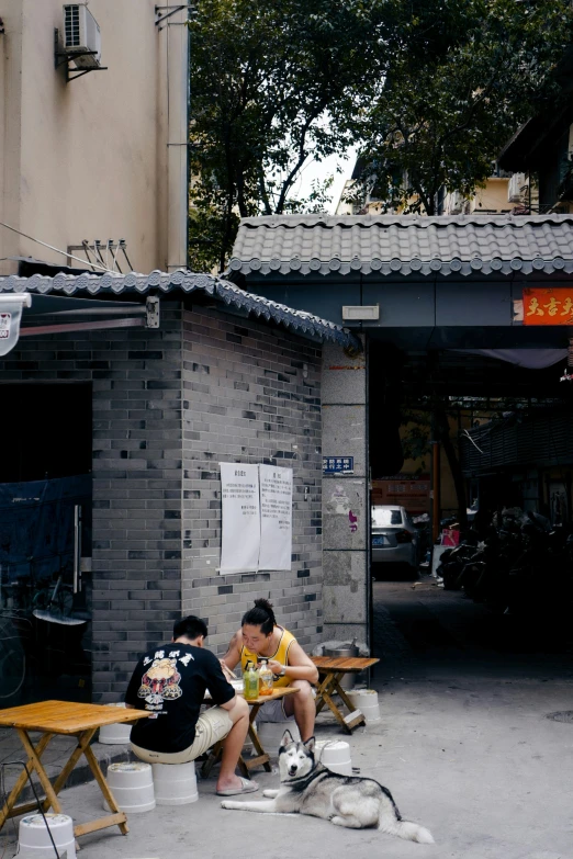 two men and dogs eating lunch on the street