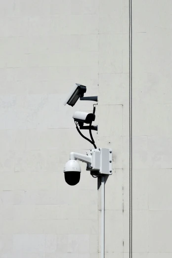 two cameras mounted to the side of a wall