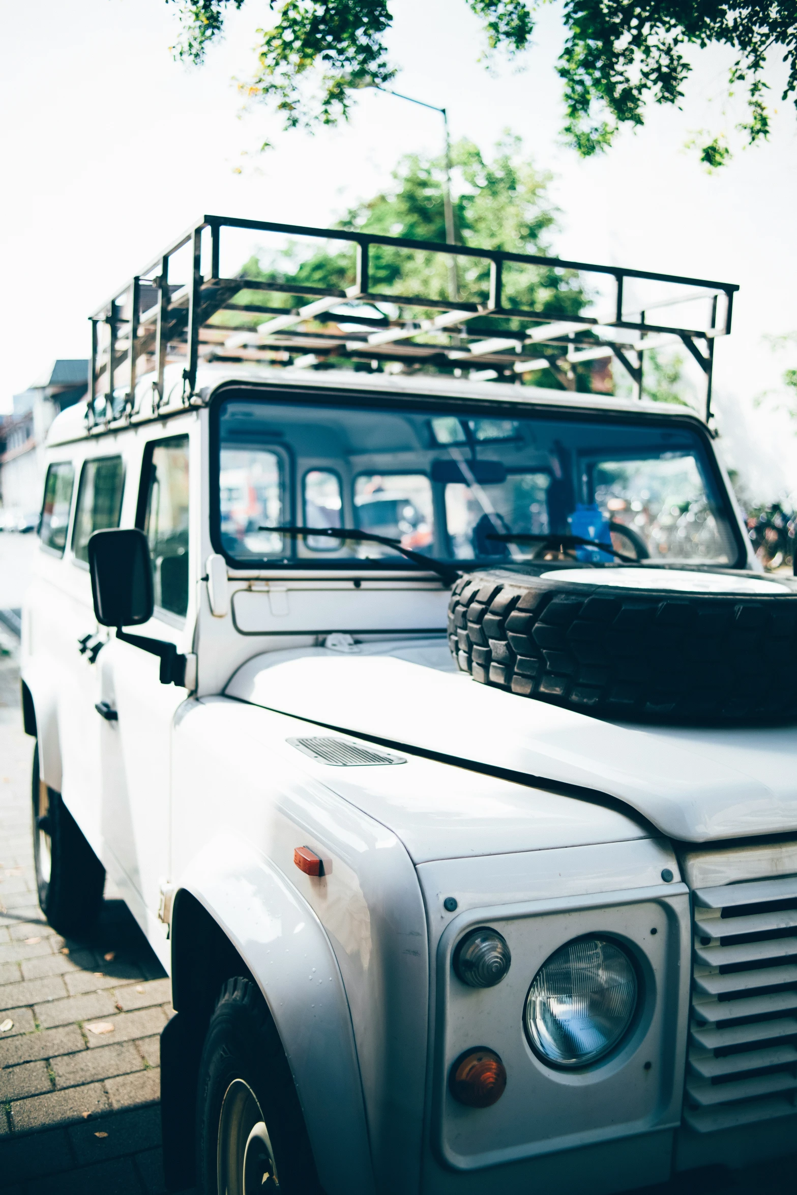 a white jeep with an open top is parked by the street