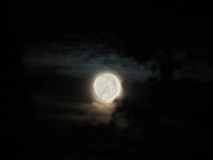 the moon shines brightly in the dark sky