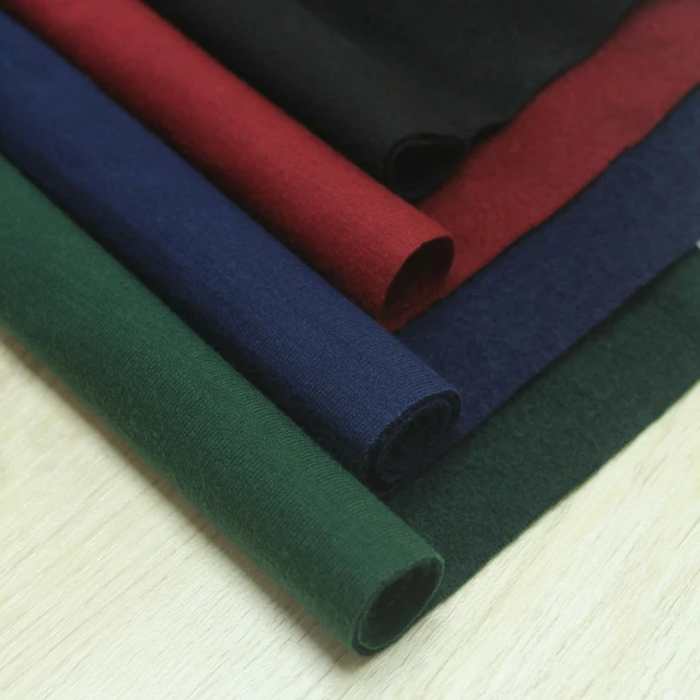 various colored fabrics folded on wooden surface
