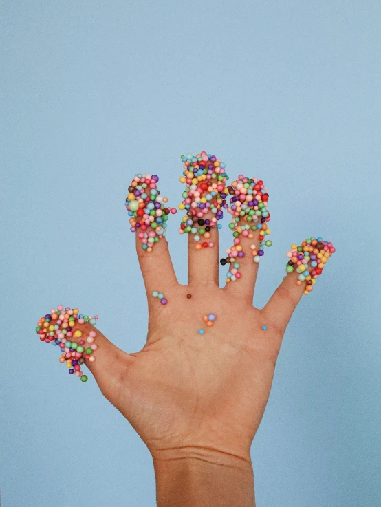 the fingers have colorful sprinkles on them