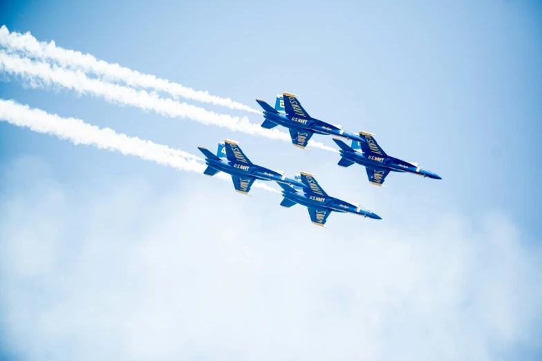 a squadron of military jets flying through a blue sky