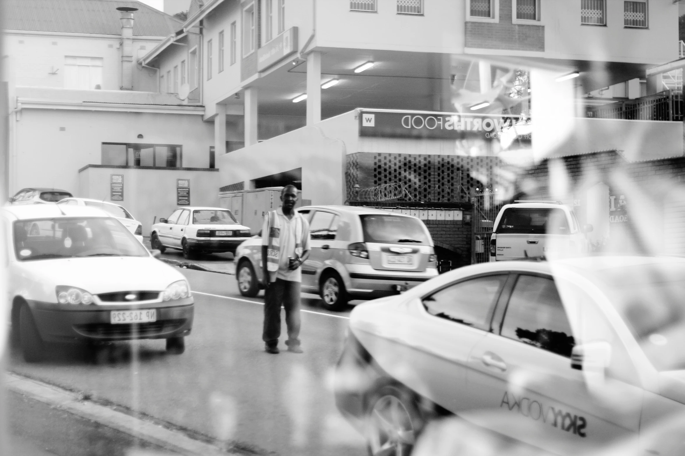 a person standing in the street with cars behind him