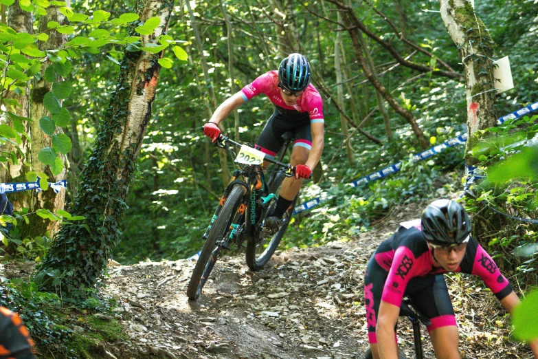 two men are racing downhill on a trail