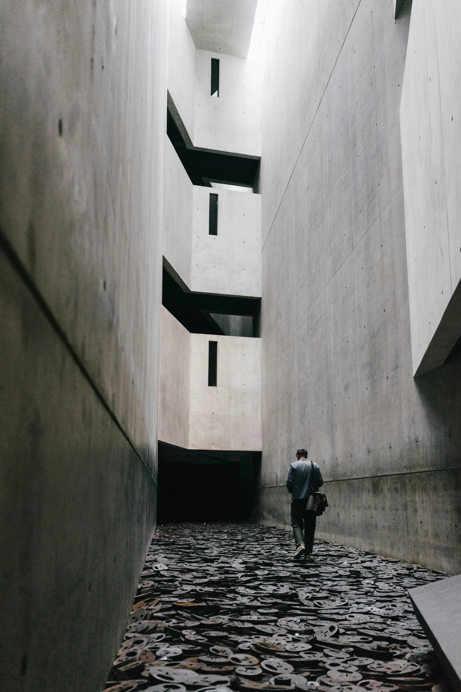 a person walks down an empty building made of concrete