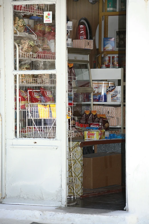 the interior of a shop with a door open to store items