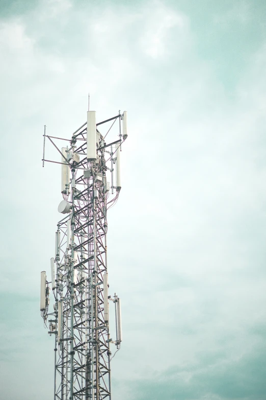 a tall tower with multiple cell towers attached to it