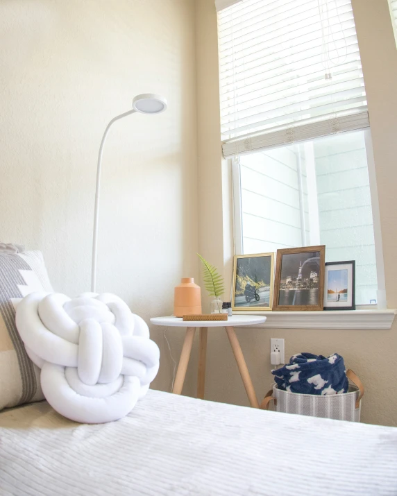 a bed with white pillows and a lamp on the side of the bed