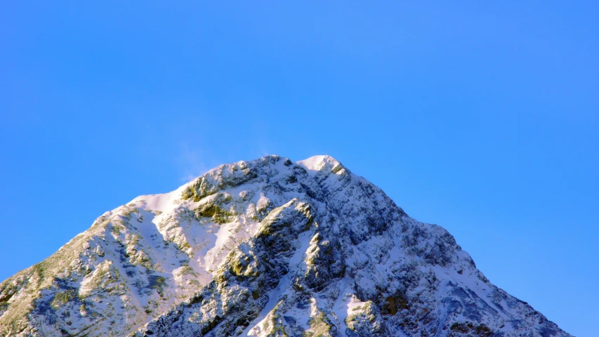 a snowy mountain with a clear blue sky