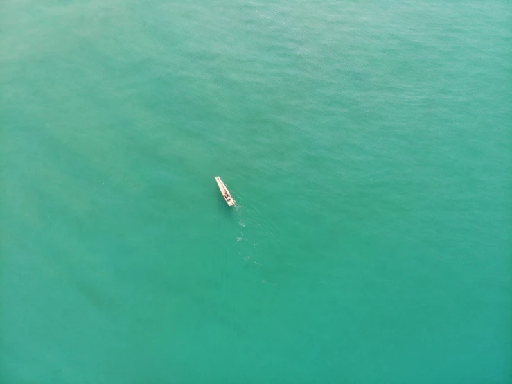 a lone boat in an ocean of blue water