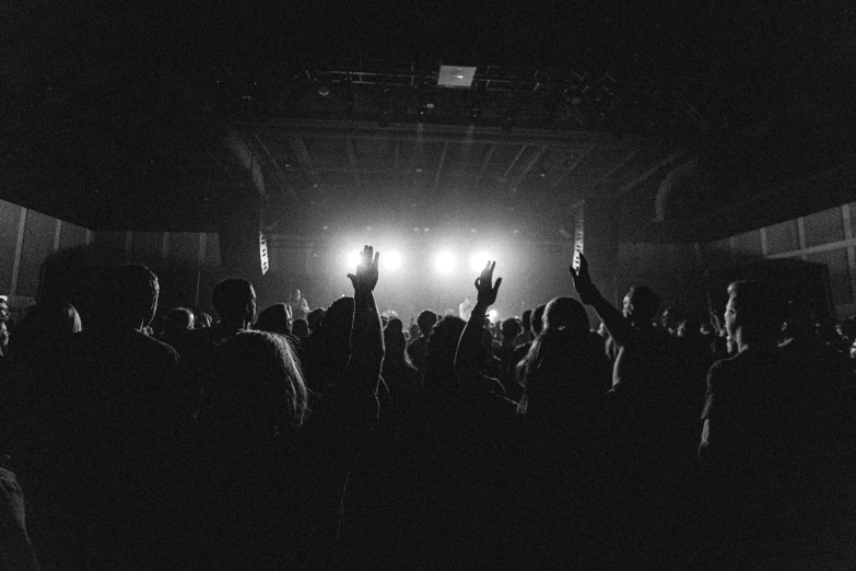 a crowd with their hands raised at a concert