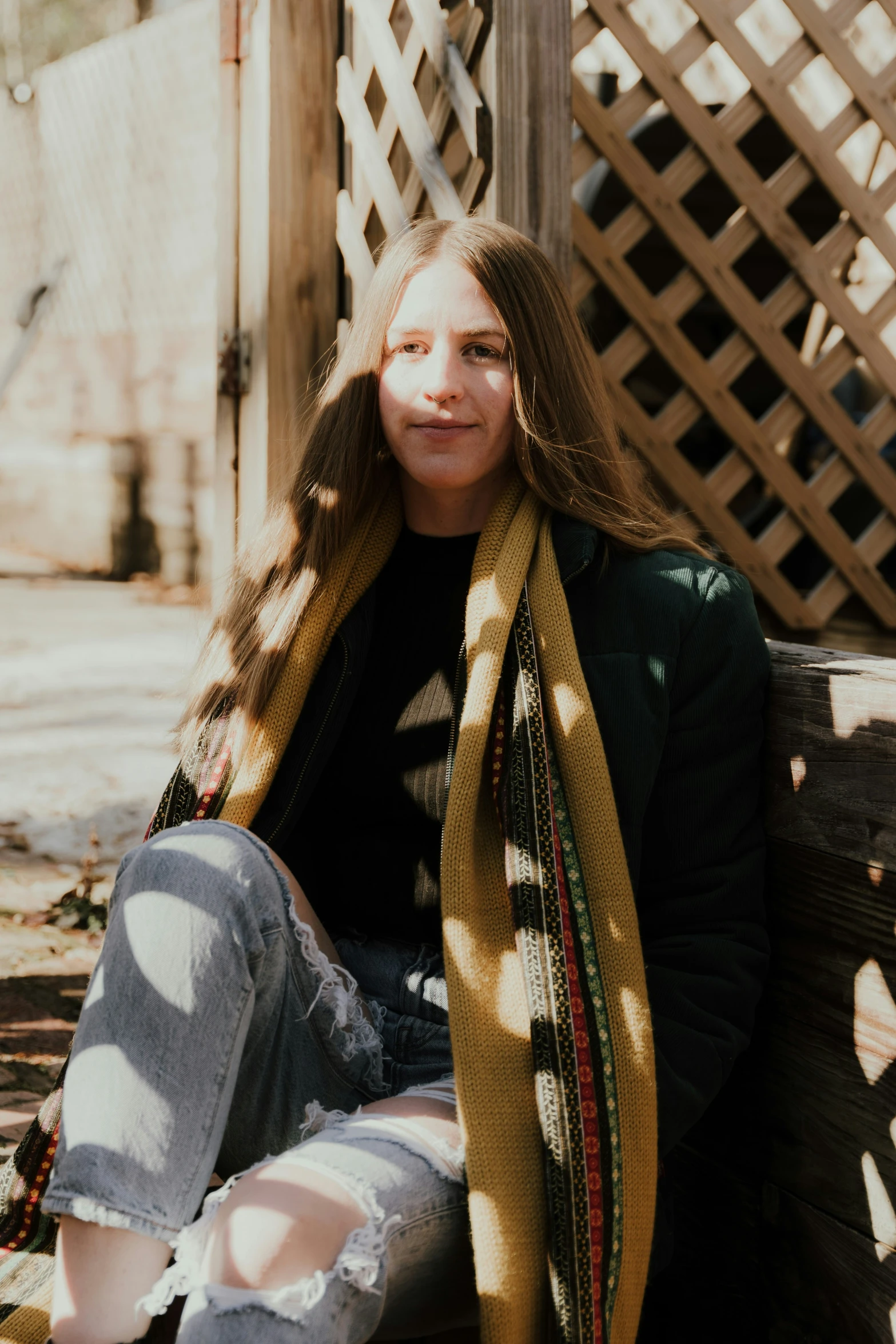 a  with long hair sitting on a wooden bench