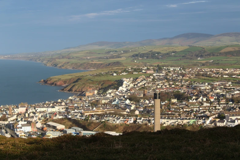 a small hill near the ocean with many houses