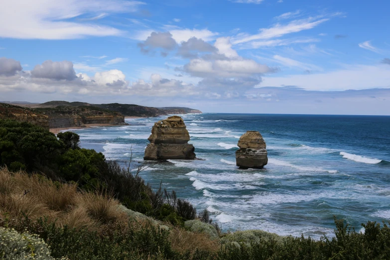 a scenic beach with a couple of cliffs in the ocean