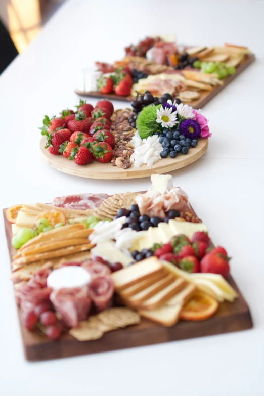 an assortment of fruit and meat platters on wooden slices