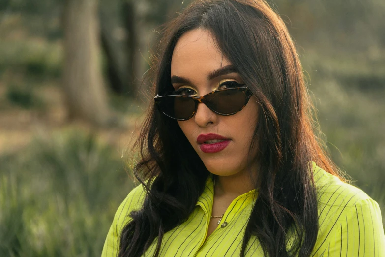 a woman with long dark hair and sunglasses on