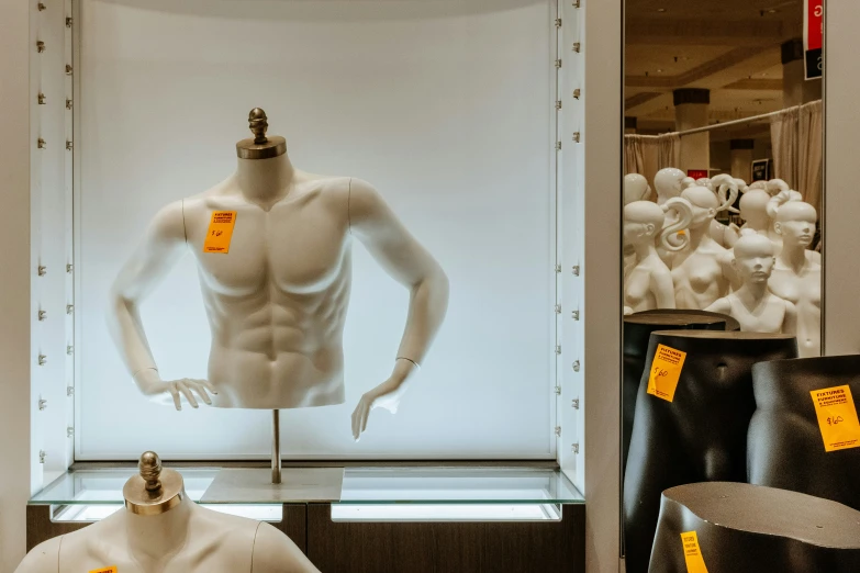 there is a display case containing a white mannequin with his arms crossed