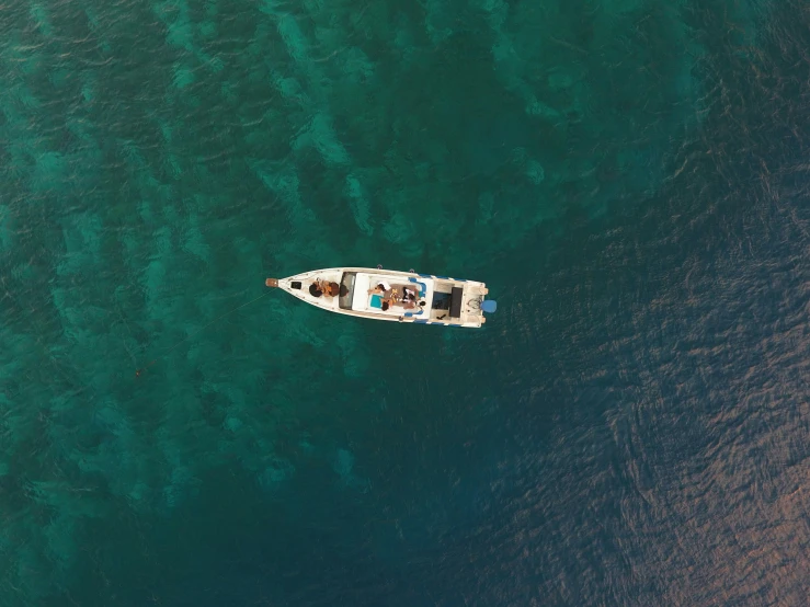 a small boat is anchored in the clear ocean water