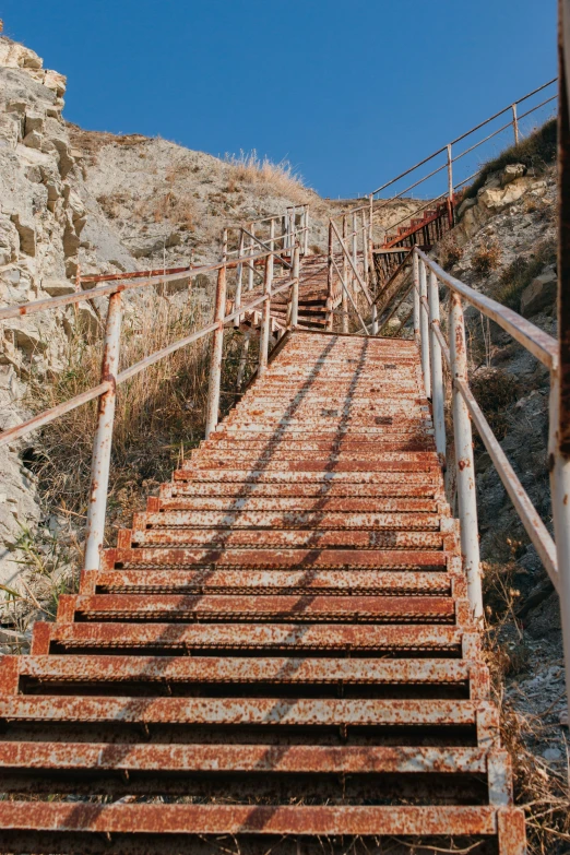 a metal stair rise up to the top of a mountain