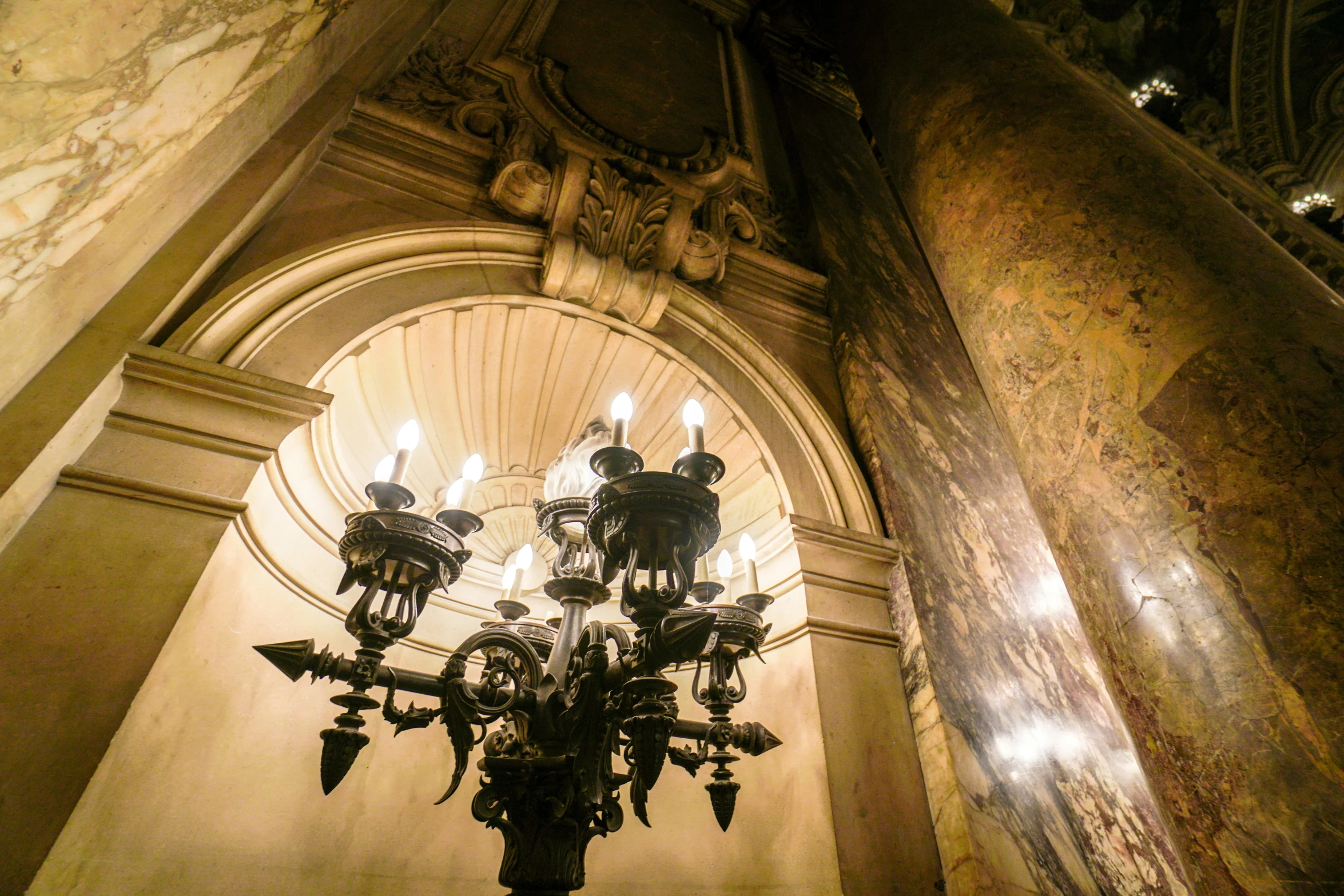 a lamp in an old building with ornate carving work