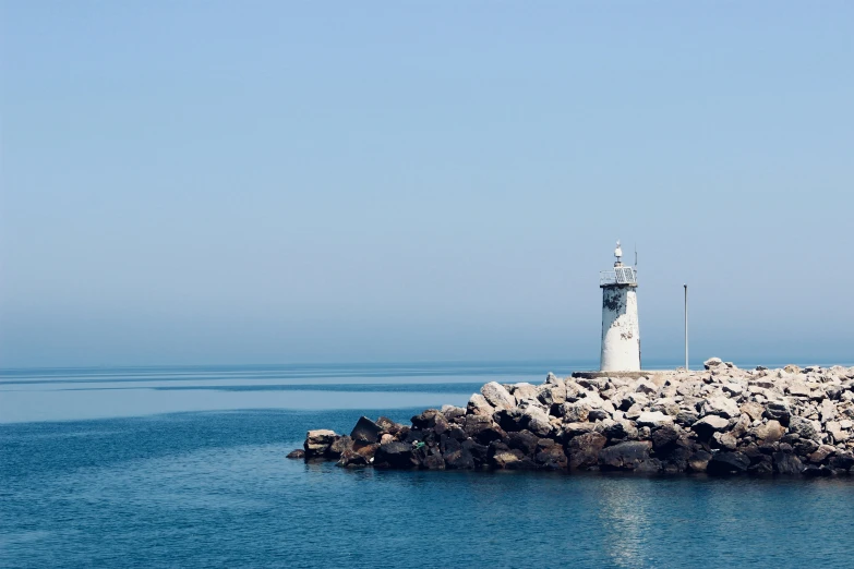 the lighthouse is sitting on top of a rock outcrop