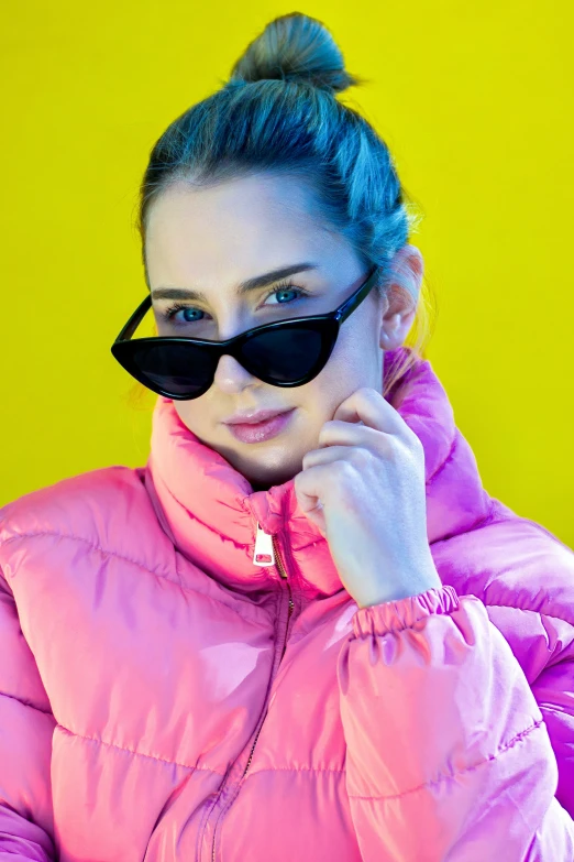 a young woman wearing a pink coat is posing for the camera