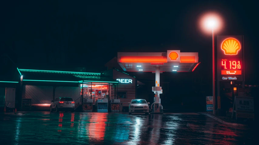 an oil station with gas pumps on a wet night