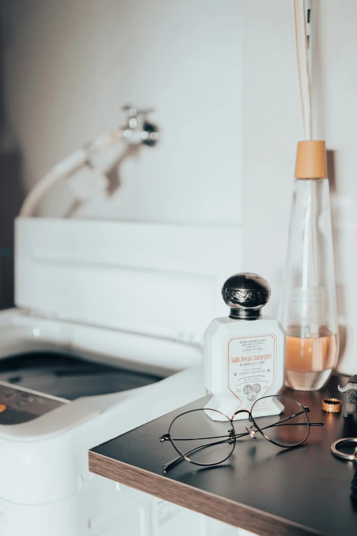 some glasses and perfume in front of a toilet