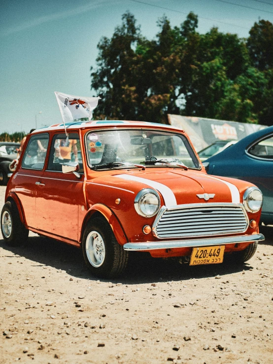 small red car parked on dirt near trees